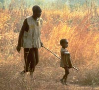 A child leading a visually impaired man